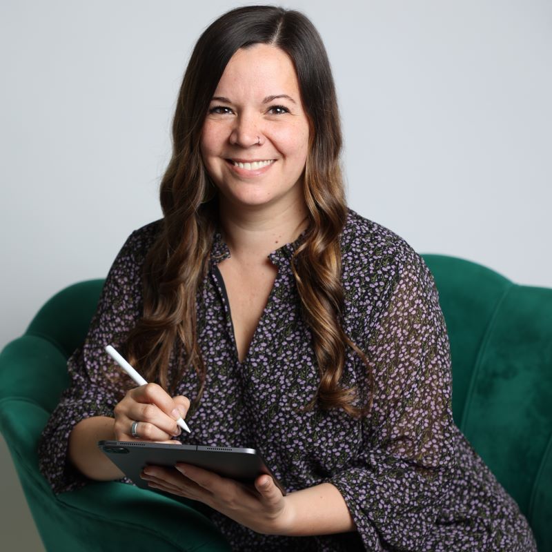 Claudia Röhrig lächelt im systemischen Coaching während sie Notizen macht.
